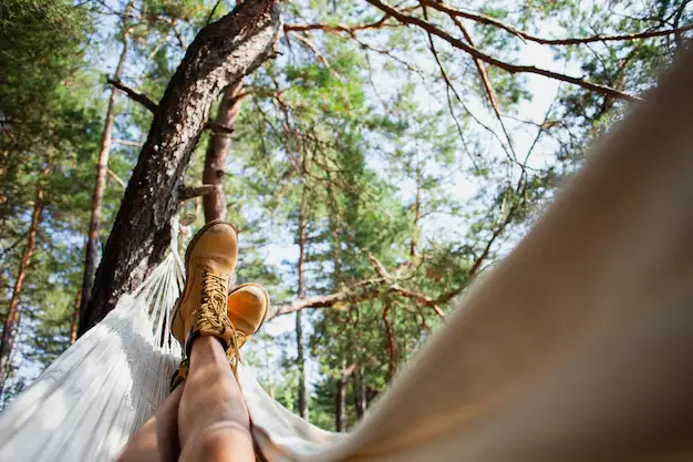 Homme détendu dans un hamac sous un arbre, bien-être et équilibre par la sophrologie à Narbonne
