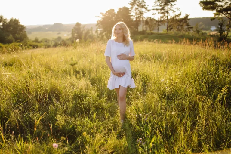 Femme enceinte marchant dans une prairie, sophrologie et grossesse à Narbonne
