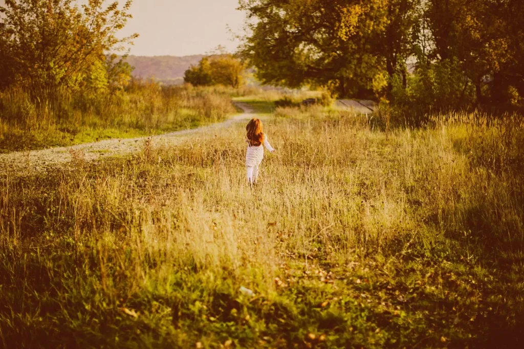Jeune fille rousse marchant dans l'herbe, sophrologie pour adolescents à Narbonne