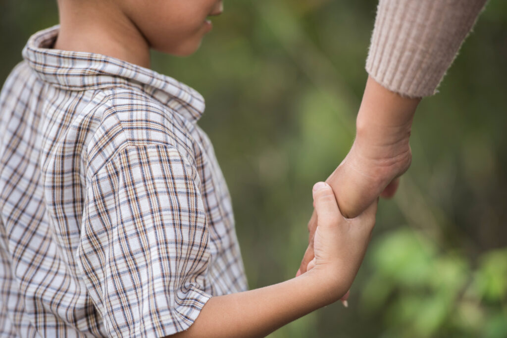 Adulte tenant la main d'un enfant, accompagnement en sophrologie pour enfants à Narbonne